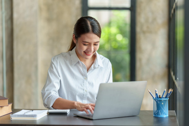 美丽年轻的亚洲女学生在家里用笔记本电脑在线学习。图片下载