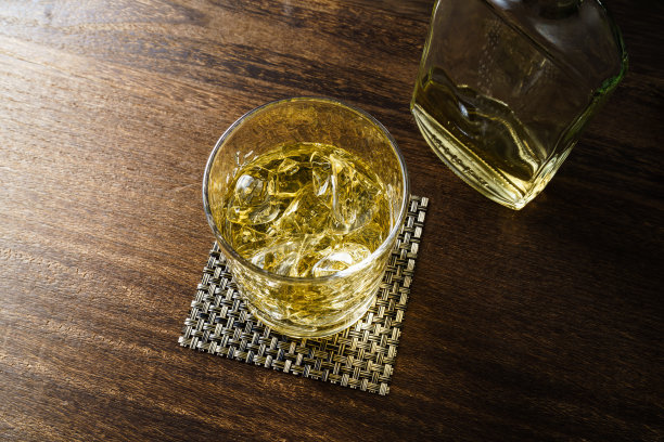 威士忌装在加冰的玻璃杯里，放在木桌上图片下载