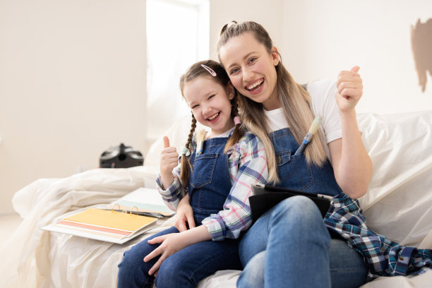 快乐的母女竖起大拇指。女孩们开始了梦想的改造。他们讨论房间的墙壁刷什么颜色，是否有必要在走廊上放一个衣架图片下载