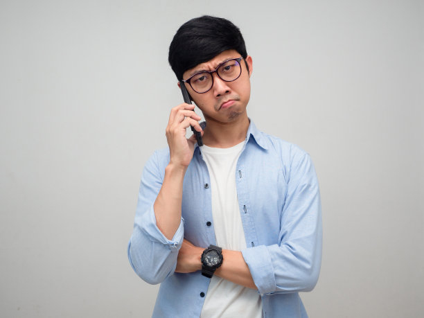 年轻的商人戴着眼镜，用手机说话，感到无聊和孤独图片下载