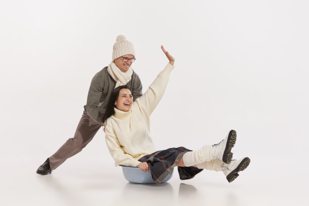 欢快的年轻夫妇的肖像，男人和女人有乐趣，滑在碗孤立的白色工作室背景图片下载