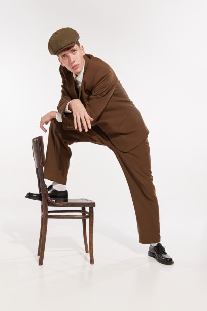 年轻男子的肖像在复古，老式的西装和帽子摆姿势孤立在白色的工作室背景图片下载