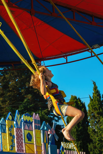 快乐的女孩在公园的游乐设施上图片下载