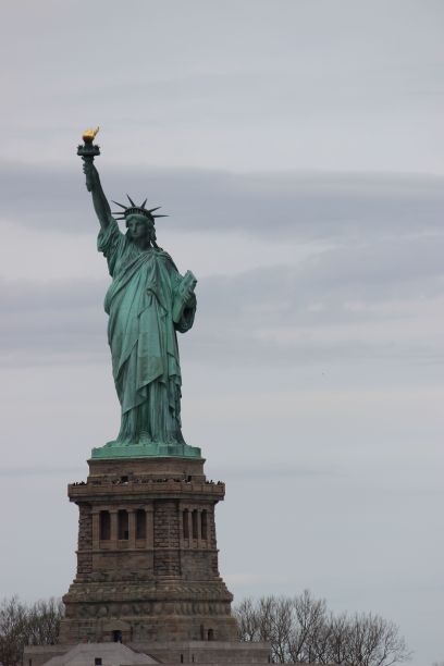 垂直拍摄的自由女神像在蓝色多云的天空背景在纽约市图片下载