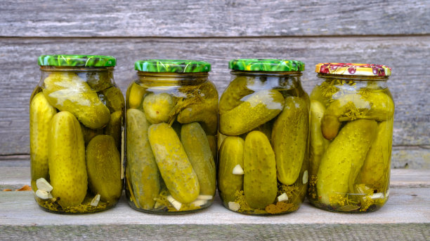 玻璃罐里装着腌黄瓜。装着各种腌制蔬菜的坛子。罐头食品的概念在乡村组成图片下载