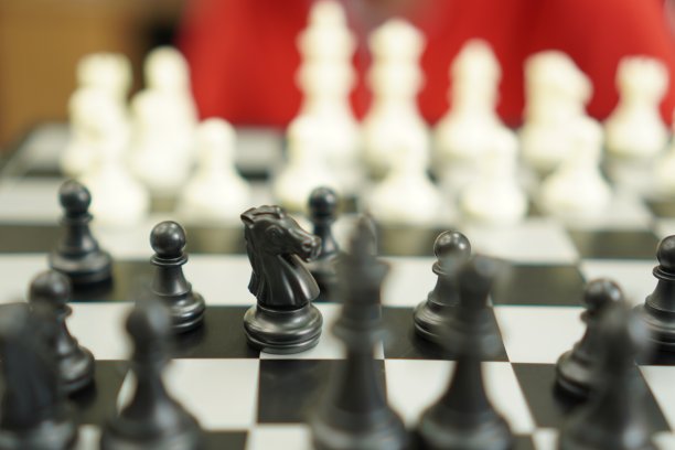 运动游戏:这幅图显示了一个棋手下棋的开始，特写。图片下载