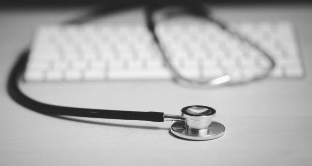 医生听诊器隔离在白色与现代电脑键盘，病毒季节，大流行。远程医疗或学习和远程医疗，复制空间在平板桌上。。图片下载