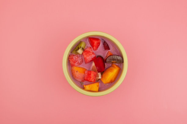 Es Campur或Sop Buah在碗上粉红色背景，俯视图。水果汤加酸奶。印尼流行的水果鸡尾酒甜点。街头咖啡馆菜单的设计元素图片下载