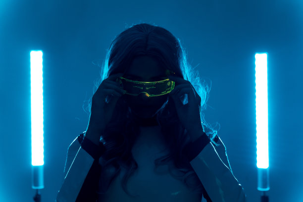 未来，一个年轻女子的剪影来自未来，与发光增强现实眼镜看着相机图片下载