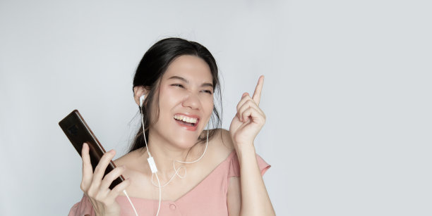 亚洲美女听着音乐，微笑着，快乐着，跳着舞。心理健康。图片下载