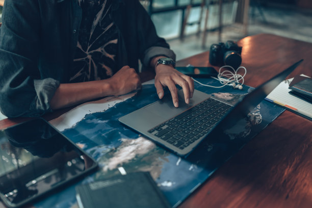旅行者计划旅行和使用笔记本电脑预订酒店，购买机票，搜索地图，或寻找旅行路线。旅行的概念。图片下载