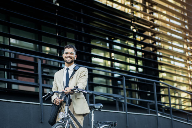肖像的商人与自行车站在办公楼前图片下载