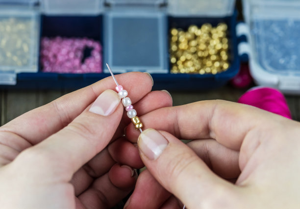 女性手中拿着金珠针图片下载