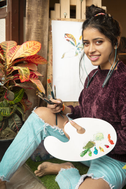 女艺术家在家里在画布上画水彩画。图片下载