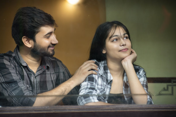 一对幸福的情侣坐在餐厅的窗户后享受闲暇时光。图片下载