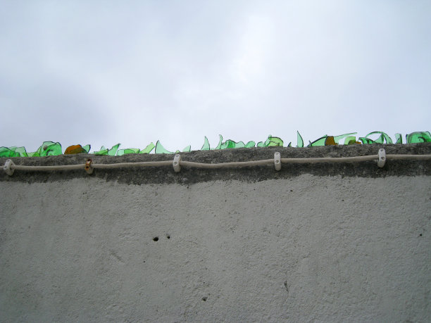 上沿砖墙上玻璃瓶的锋利碎片图片下载