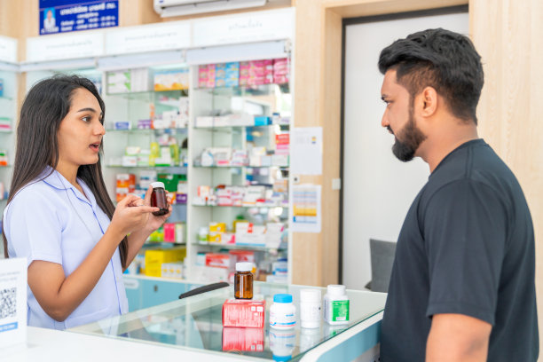 印度女药剂师在药店向男顾客讲解药品和补品。图片下载