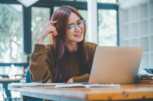 年轻的学生戴着耳机在线学习、远程学习，并了解全球冠状病毒大流行的最新情况。图片下载