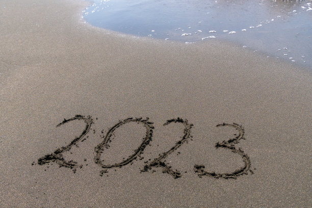 文字2023年新年快乐，沙滩上有小波浪。即将到来的2023年新年的抽象背景照片图片下载