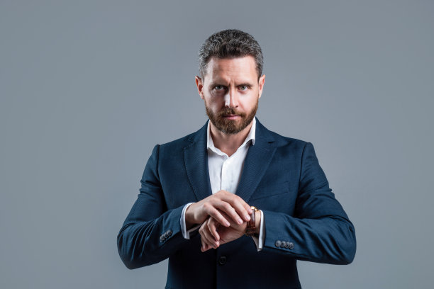 CEO西装革履，胡子梳理整齐，展示腕表，查看时间图片下载