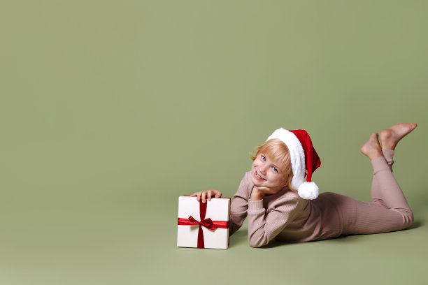 绿色背景的圣诞礼物女孩。图片下载