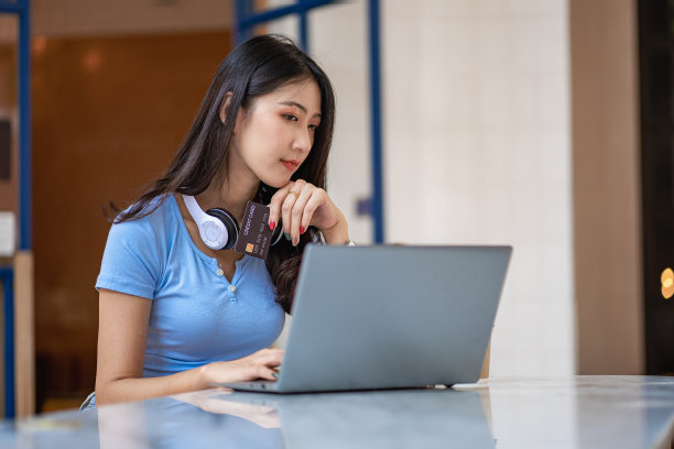 美丽的亚洲女性在网上用信用卡付款或进行金融交易。图片下载