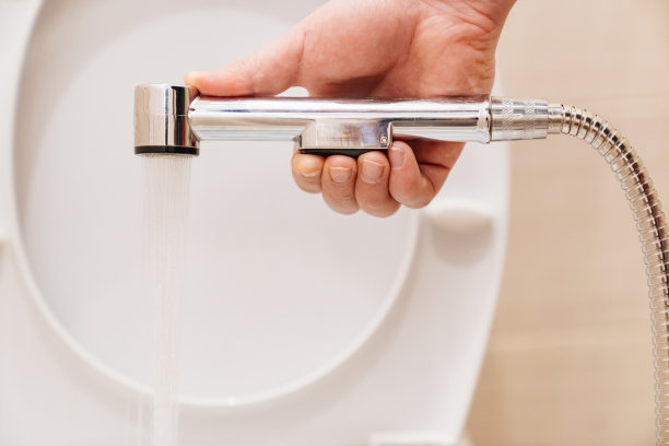 一名男水管工正在修理浴室里的卫生淋浴喷头。图片下载