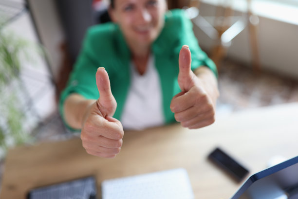 成功的商业女性在办公室的工作场所竖起大拇指图片下载