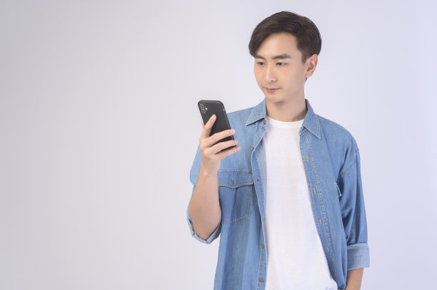 年轻的亚洲人在白色背景下使用智能手机，技术概念。图片下载