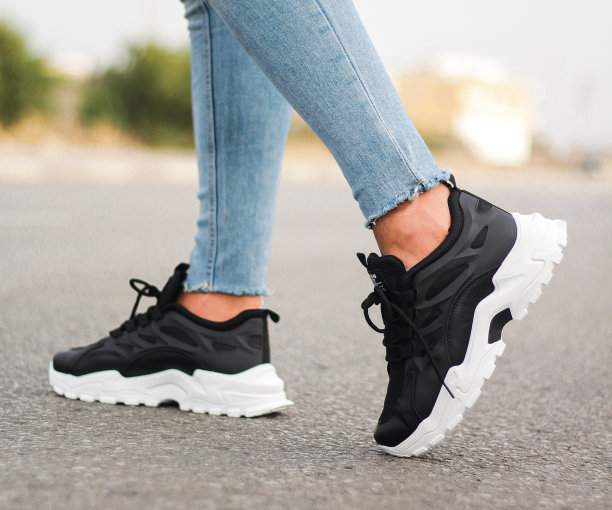 一个穿着运动鞋的男人走在街上。男人的运动鞋图片下载