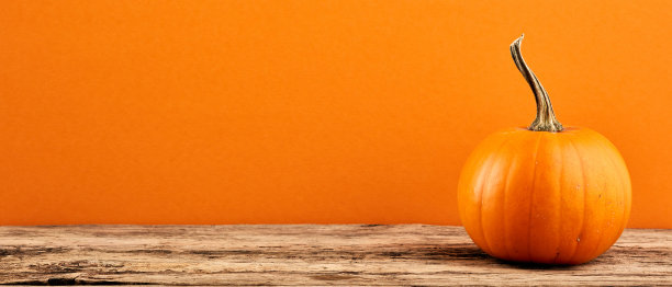 南瓜在木制桌面上橙色的背景。万圣节快乐，感恩节快乐，丰收快乐。图片下载