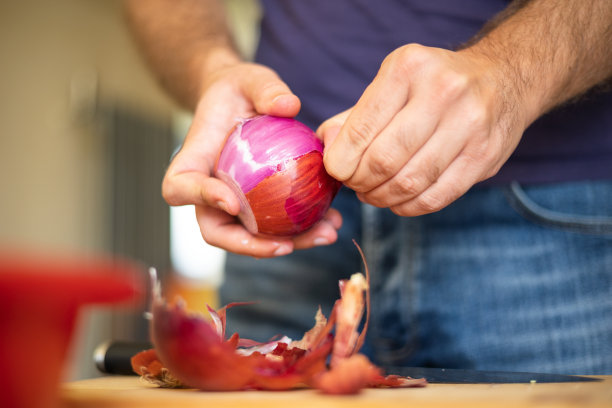 近距离剥红洋葱的人图片下载