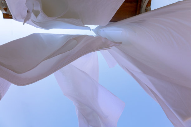 希腊塞米岛渔村的晾衣绳上晾晒着白色亚麻。雪白的床单在风中散落。底视图图片下载