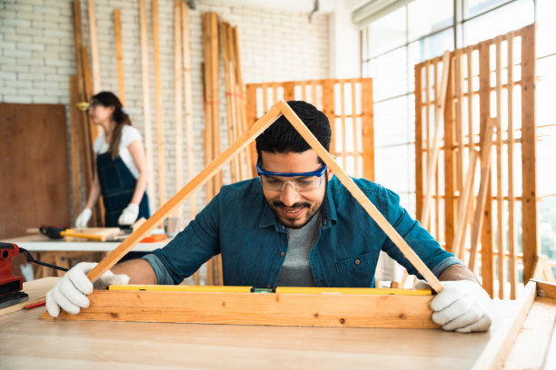 男木匠用工具测量产品板材的碎片，为家具的组装做准备。图片下载