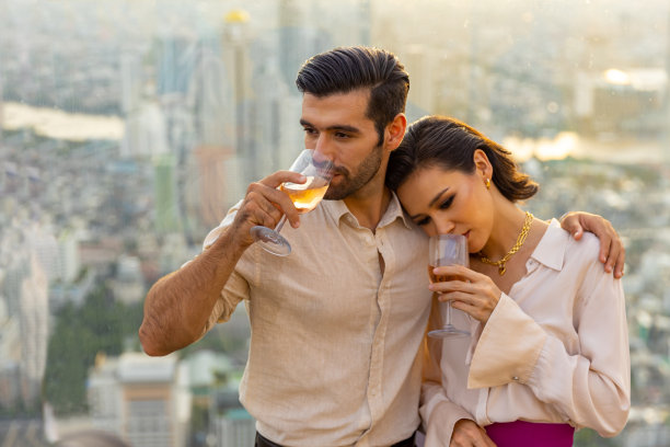 白种夫妇在夏季日落时在豪华屋顶酒吧庆祝节日活动图片下载