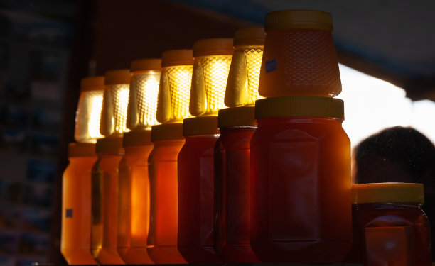 一罐一罐的天然蜂蜜放在商店的橱窗上图片下载