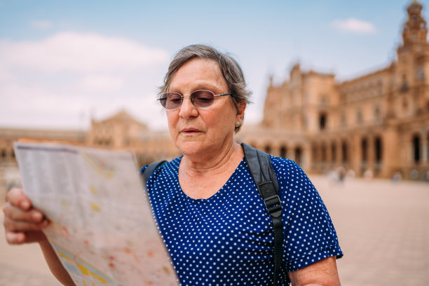 老妇人在看地图，决定去城里参观什么。一位在欧洲城市旅行的高级女士。图片下载
