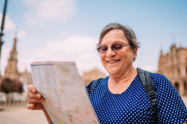 老妇人在看地图，决定去城里参观什么。一位在欧洲城市旅行的高级女士。图片下载