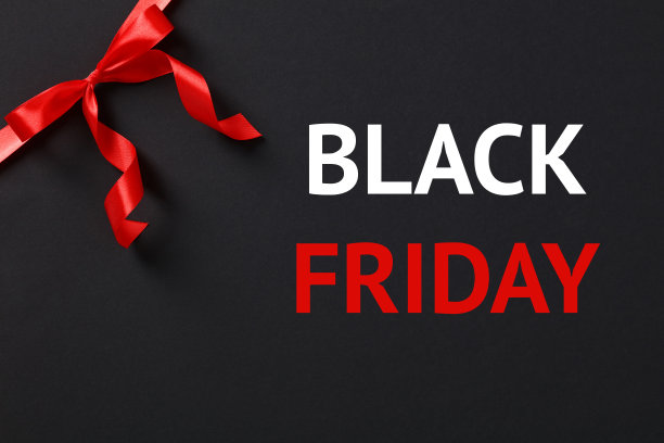 黑色星期五销售概念与红色丝带蝴蝶结在角落上的黑色背景。图片下载