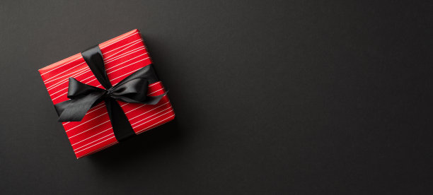 “黑色星期五”的概念。顶视图照片红色礼盒丝带蝴蝶结上孤立的黑色背景与copyspace图片下载