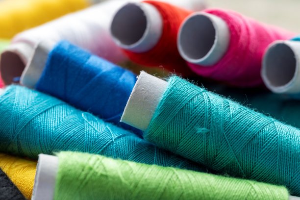 一幅由多个线轴相互叠加而成的肖像。每卷纤维都有不同的颜色。纱线或金属丝已经准备好用于一些针线活或缝纫项目。图片下载