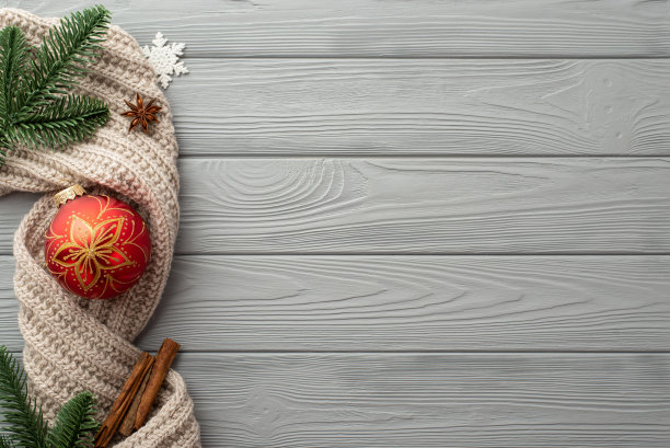 圣诞装饰品的概念。顶视图照片红色小花絮雪花松枝针织围巾八角和肉桂棒在灰色木桌背景与copyspace图片下载