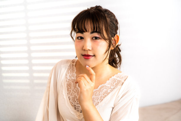 床上的年轻女子通过百叶窗接受阳光图片下载