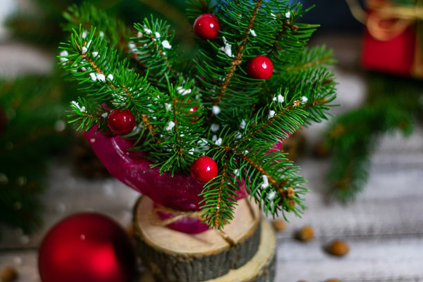 针叶树树枝的特写照片，与圣诞玩具和模仿雪，站在一个花瓶在木桌上。从上面的观点图片下载