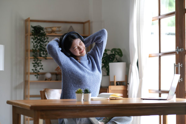 年轻迷人的亚洲女性放松交叉手臂后脑使用笔记本电脑数字在线课程计划在检疫在家里，再技能学校班为职业道路。图片下载