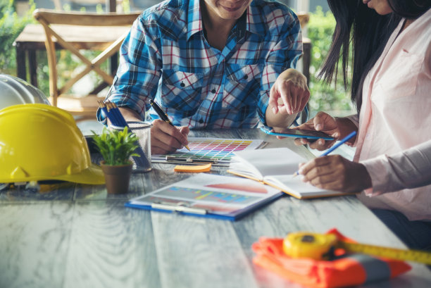 土木建筑工程师团队在施工现场开会，团队穿着安全服，信任团队在桌子上看蓝图，一起咨询安全安全帽建筑工程师的概念图片下载