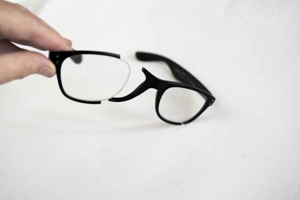 白种人的手拿着破碎的眼镜框。图片下载