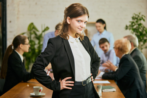 年轻漂亮的女商人升职了，完成了成功的项目，看着镜头，微笑着。成功，工作，事业和商业图片下载