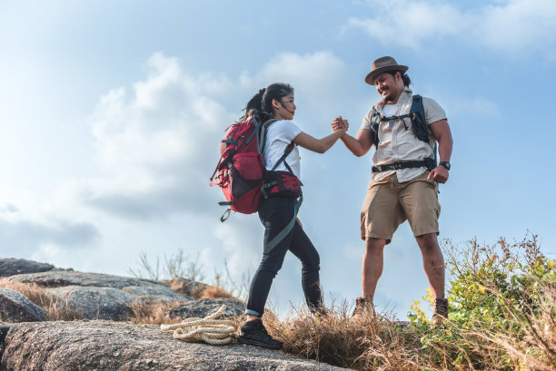 背包客，亚洲男女，登山者。携手登上山顶，团结成功理念。图片下载