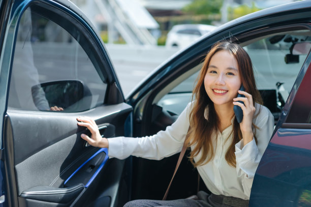 亚洲商务女性下了车，拿着手机和咖啡杯，右手驾驶，左手交通，商务女性，白人商务舱豪华图片下载